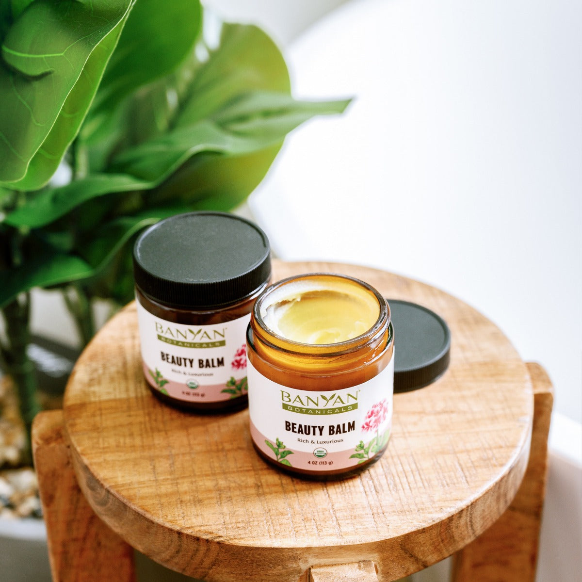 Beauty Balm jars sitting on wood stool one open showing balm
