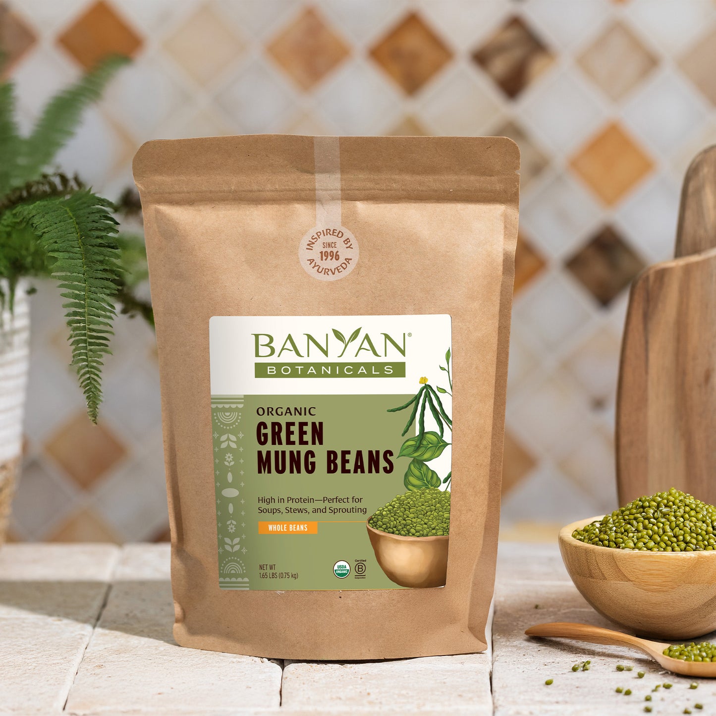 Kraft bag of green mung beans on counter next to bowl and spoon of green mung beans